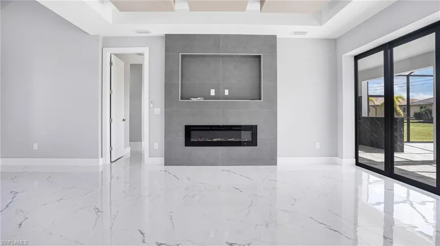 Unfurnished living room with a fireplace and a raised ceiling