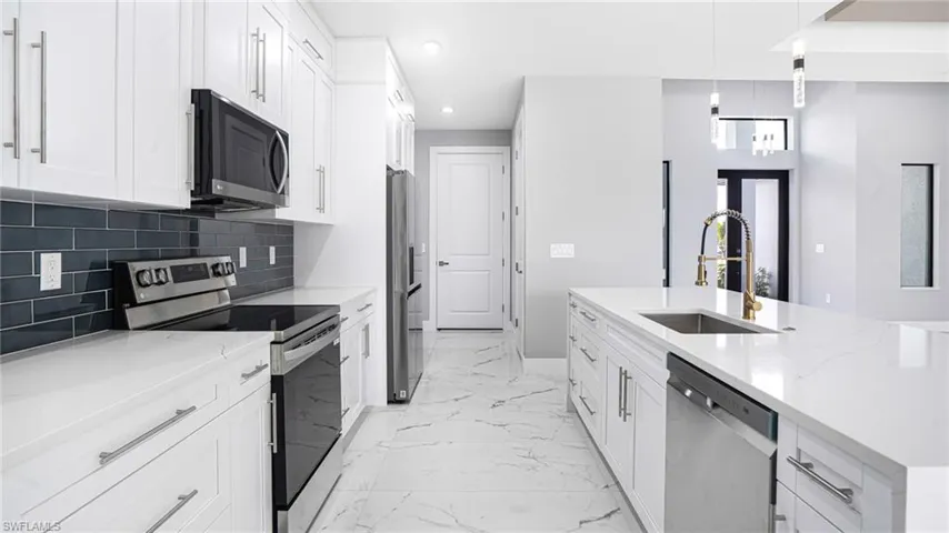 Kitchen with white cabinets, stainless steel appliances, and sink