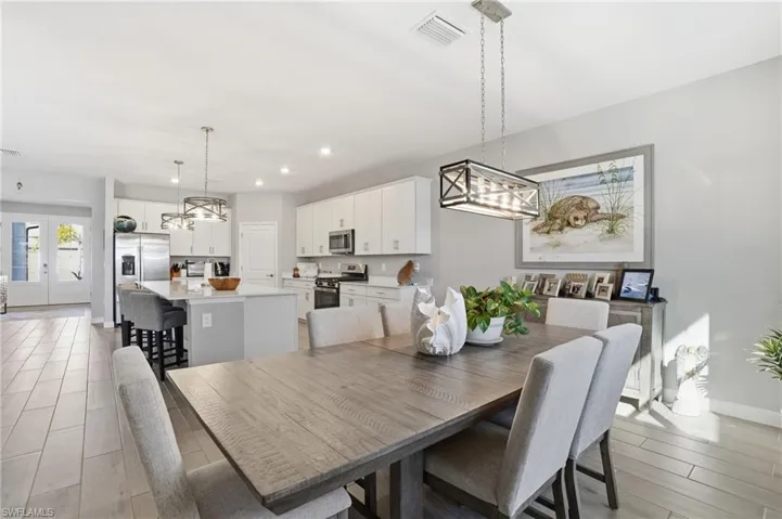 Dining area featuring a chandelier, light wood-style flooring, and recessed lighting