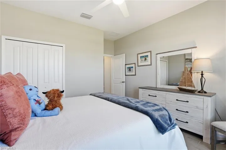 Bedroom with light wood-style flooring, a closet, and ceiling fan