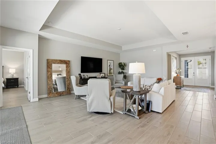 Living area featuring a raised ceiling and light wood finished floors