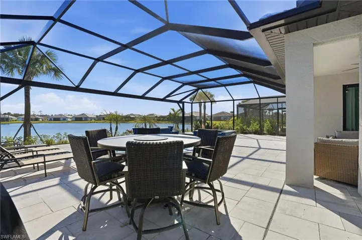 View of patio / terrace featuring a residential view, a sunroom, a lanai, and a water view