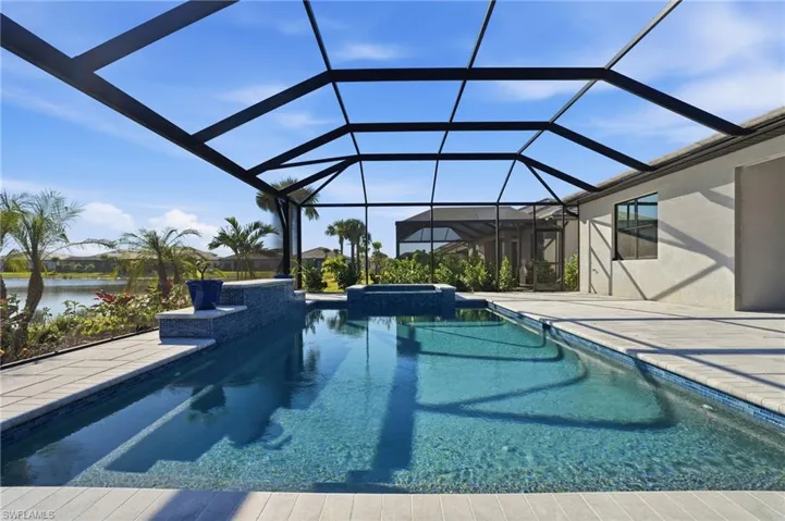 View of pool with a pool with connected hot tub, a lanai, and a sunroom