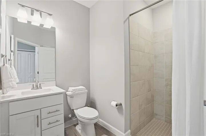 Bathroom with a stall shower, vanity, and wood finished floors