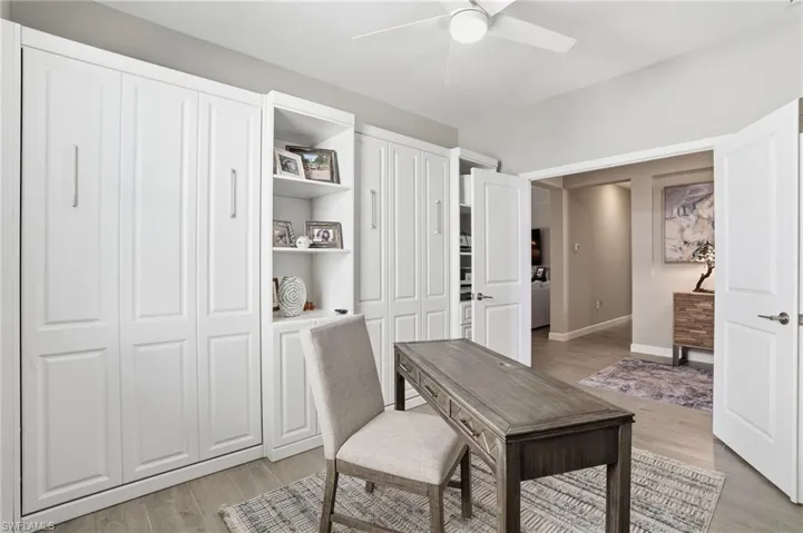 Office area with light wood-style flooring and a ceiling fan