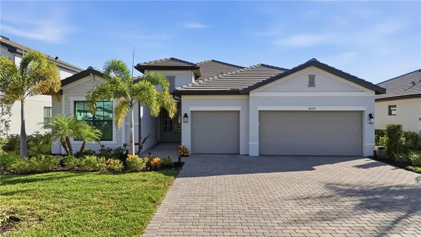 Single story home with decorative driveway, stucco siding, a garage, and a front yard