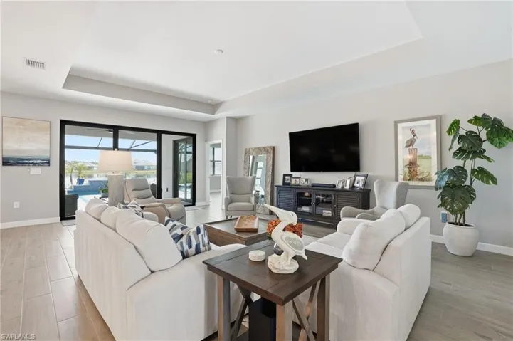 Living area with a raised ceiling and light wood finished floors