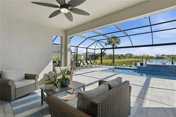 View of patio with glass enclosure, a sunroom, a residential view, an outdoor pool, and ceiling fan
