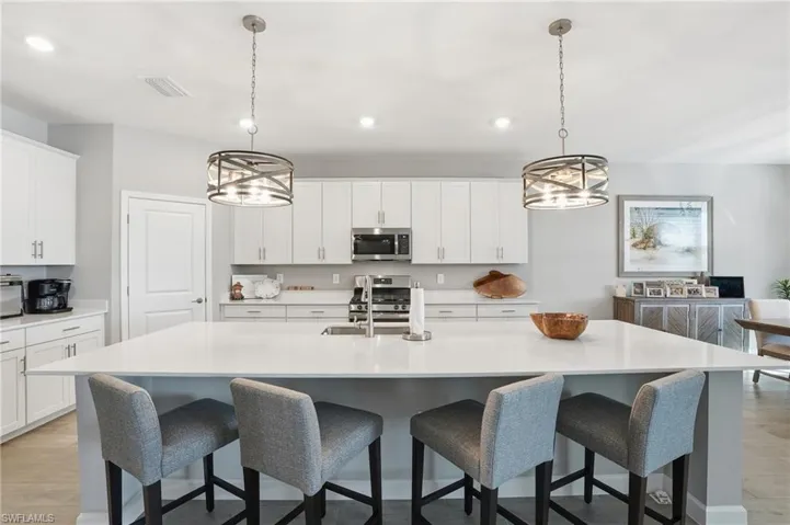 Kitchen featuring a chandelier, light wood-style floors, white cabinetry, and recessed lighting