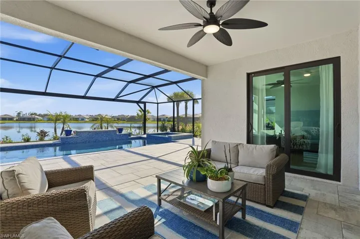 View of patio with a sunroom, glass enclosure, a pool with connected hot tub, and an outdoor living space