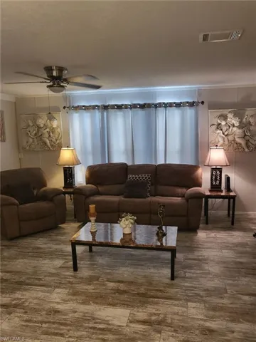 Living room with wood finished floors and a ceiling fan