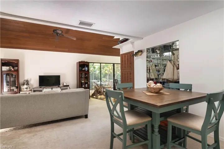 Dining room with light colored carpet and a ceiling fan