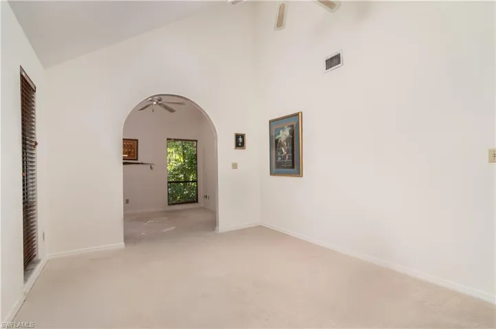 Master bedroom with carpet, high vaulted ceiling, a ceiling fan, and arched walkways