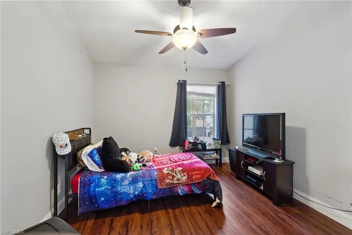 Bedroom with ceiling fan and dark hardwood / wood-style flooring