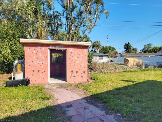 View of outbuilding with an outdoor structure and fence