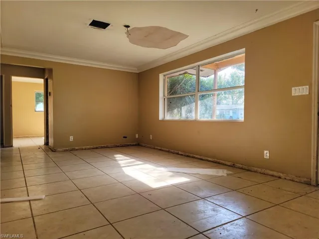 Spare room with light tile patterned floors and ornamental molding