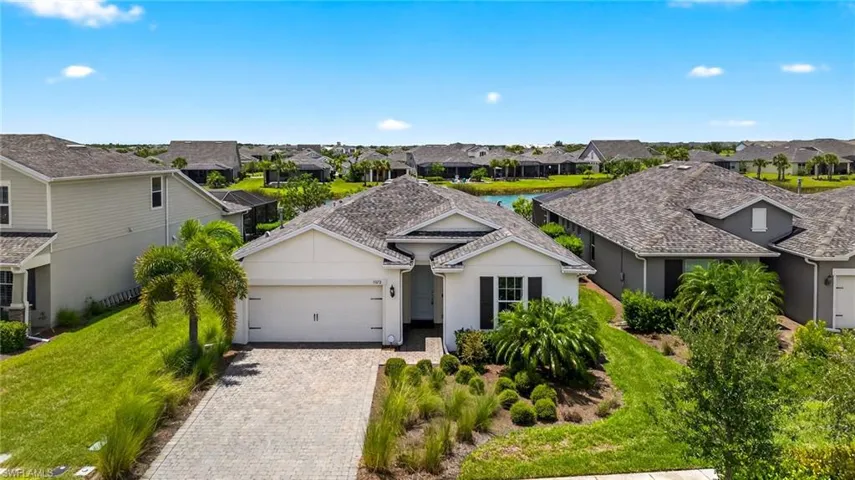 Ranch-style home with a residential view, a garage, decorative driveway, and stucco siding