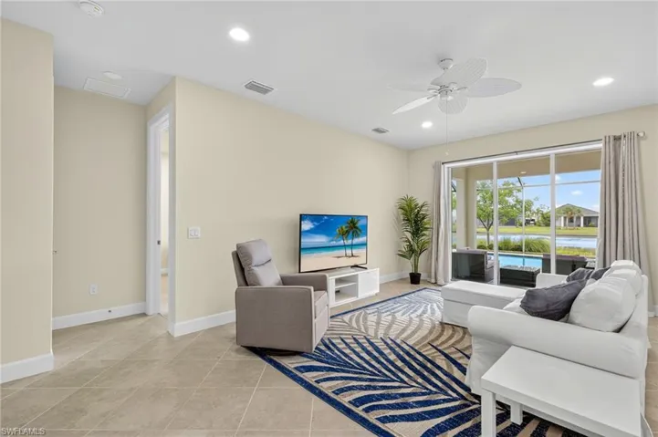 Living area with a ceiling fan, recessed lighting, and light tile patterned flooring
