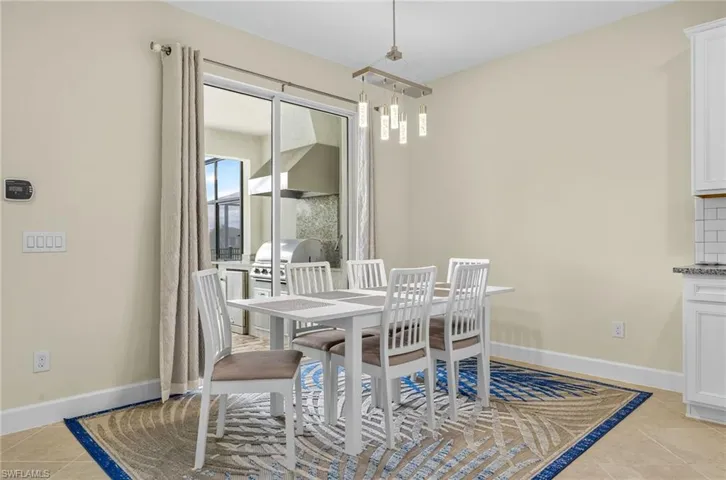 Dining area with light tile patterned floors and baseboards