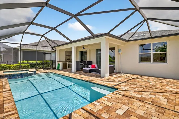 View of swimming pool with a patio, ceiling fan, a pool with connected hot tub, an outdoor living space, and glass enclosure