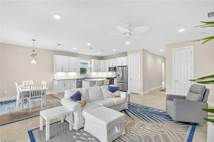 Living area featuring light tile patterned flooring, ceiling fan, and recessed lighting