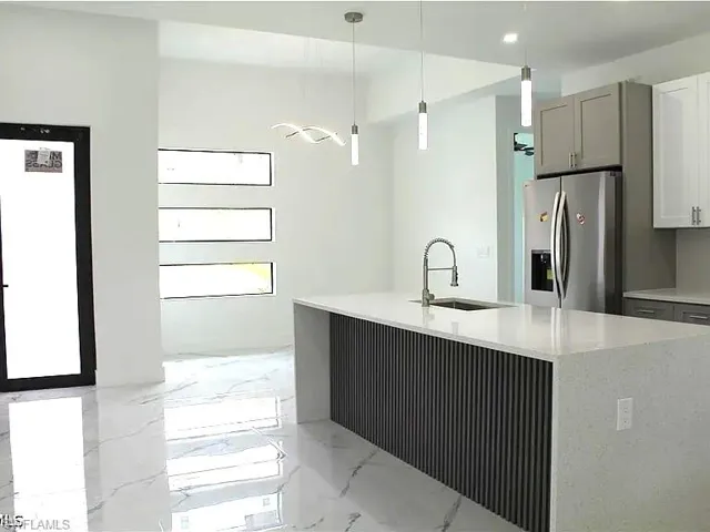 Modern kitchen island with a quartz countertop, integrated sink, and an industrial-style faucet