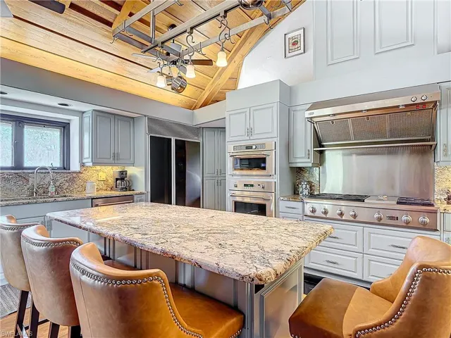 Kitchen featuring wood ceiling, a center island, extractor fan, vaulted ceiling, and stainless steel appliances
