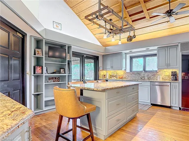 Kitchen featuring a ceiling fan, dishwasher, wooden ceiling, light wood-style flooring, and a center island