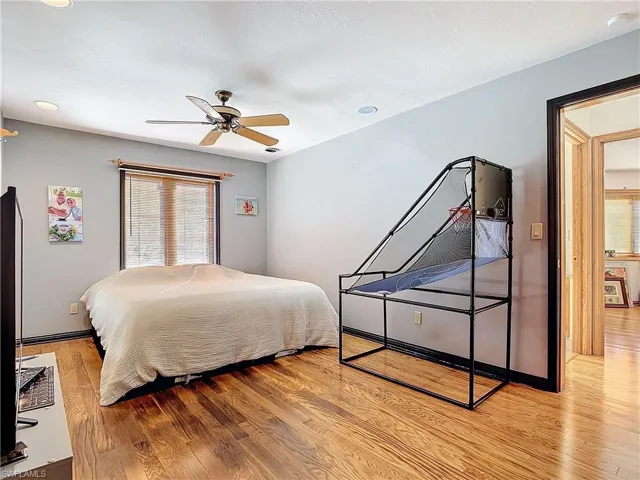 Bedroom with a ceiling fan, baseboards, and light wood finished floors