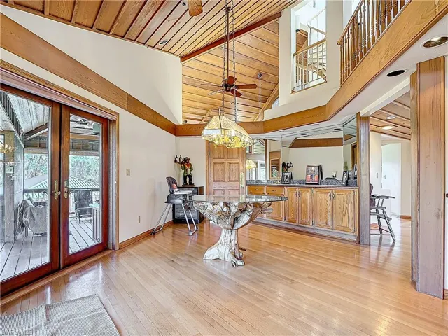 Dining room with light wood-style floors, french doors, high vaulted ceiling, and a ceiling fan