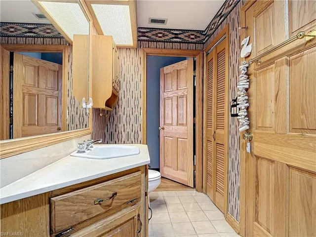 Bathroom with visible vents, tile patterned flooring, vanity, and toilet