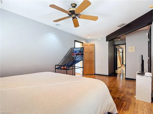 Bedroom featuring a ceiling fan, light wood-style flooring, visible vents, and baseboards