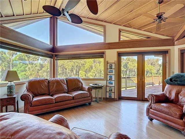 Living room with ceiling fan, french doors, vaulted ceiling, and plenty of natural light