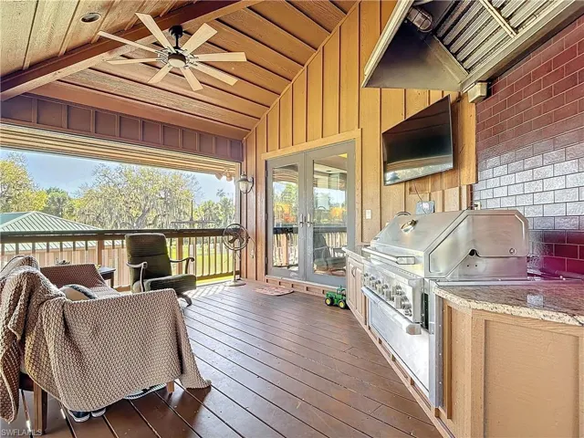 Wooden terrace featuring ceiling fan, grilling area, area for grilling, and french doors