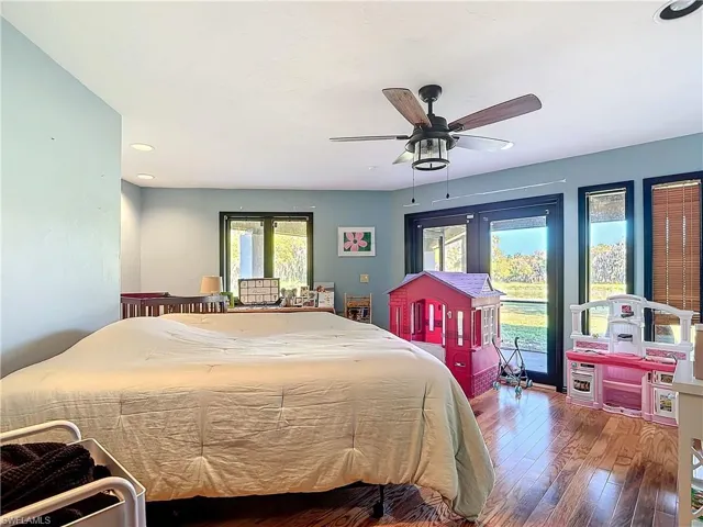 Bedroom with access to outside, ceiling fan, and hardwood / wood-style floors
