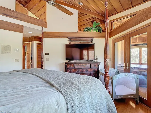 Bedroom featuring high vaulted ceiling and wood finished floors