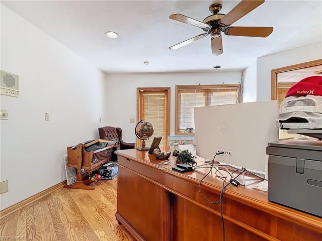 Home office with light wood-type flooring, baseboards, and a ceiling fan