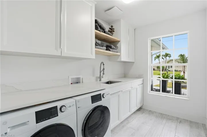 Laundry area featuring cabinet space, washer and clothes dryer, and light wood-style flooring