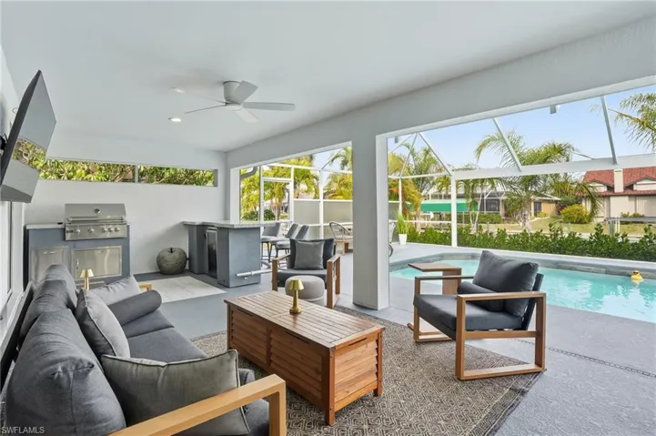 Sunroom / solarium featuring an outdoor kitchen and area to lounge, a patio area, and ceiling fan