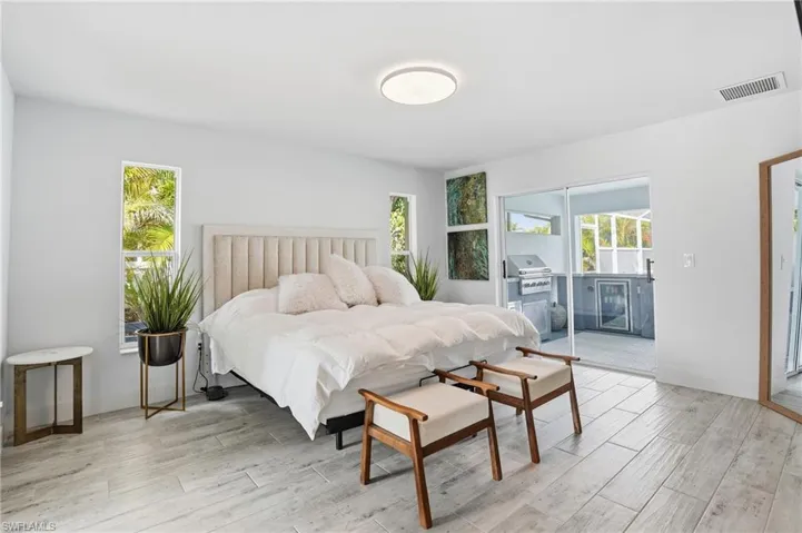 Bedroom featuring access to outside, light wood finished floors, and wine cooler