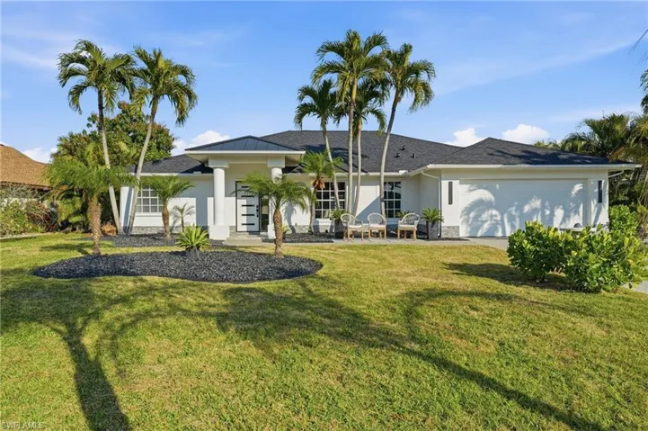 View of front of home featuring an attached garage, stucco siding, and a front lawn
