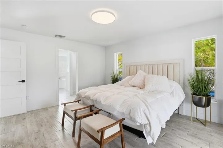 Bedroom with light wood-type flooring and ensuite bath