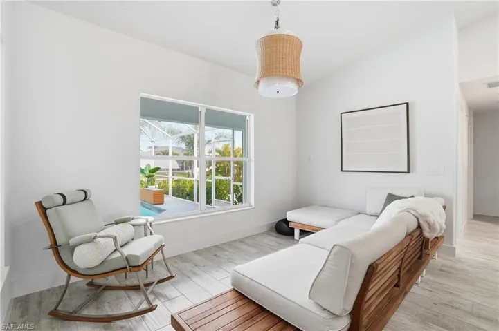 Sitting room with light wood-style floors and vaulted ceiling