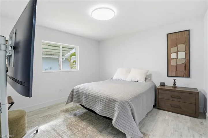 Bedroom with light wood finished floors and baseboards