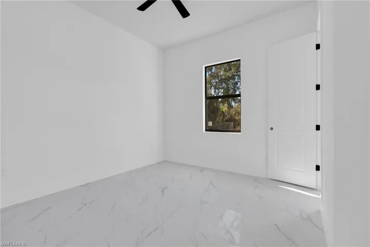 Unfurnished bedroom featuring marble finish flooring and ceiling fan