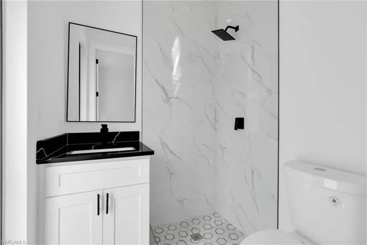 Full bath with vanity and a marble finish shower