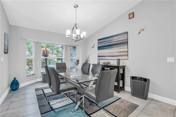 Tiled dining space with an inviting chandelier and lofted ceiling