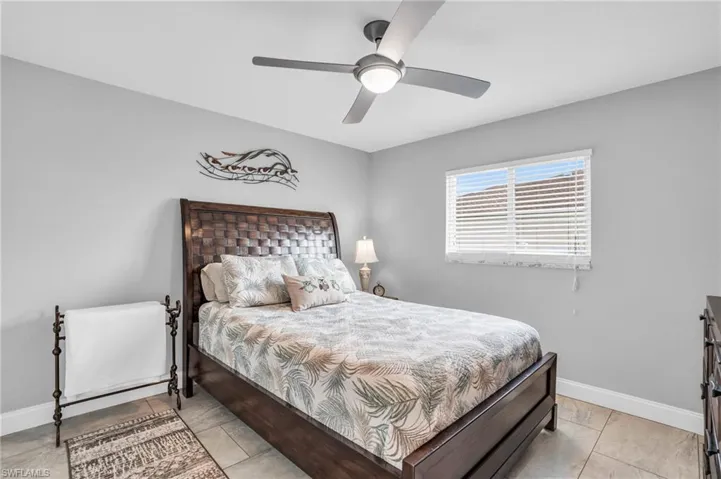 Bedroom with light tile patterned flooring and ceiling fan