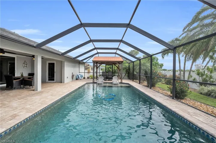 View of swimming pool featuring a patio and a lanai