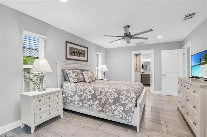 Tiled bedroom with connected bathroom and ceiling fan